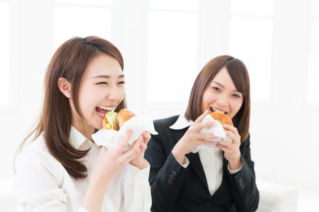 ハンバーガーを食べる二人の女性